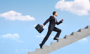 Image of confident businessman with briefcase walking upstairs